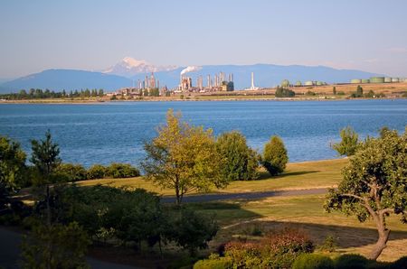 An oil refinery and tanks on the Puget Sound at Anacortes Island, Washington, with Mount Baker in...
