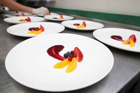 Chef in hotel or restaurant kitchen making dessert for dinner