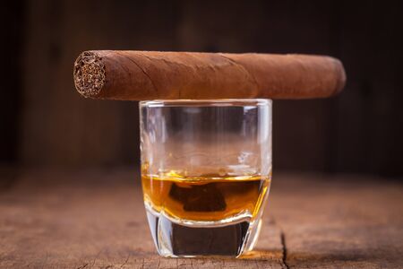cigar and whisky on old wooden tableの写真素材
