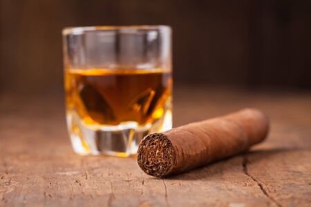 cigar and whisky on old wooden tableの写真素材
