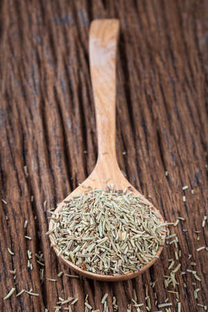 dry rosemary in spoon on the old wood tableの写真素材