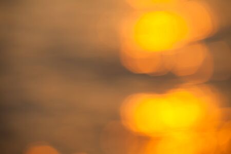 blurry background of bokeh on water sea from sun light at evening