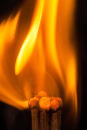 Match and blaze of fire on match isolated on black background