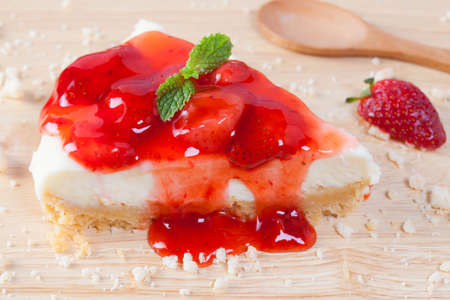 Close up strawberry cake on wooden plate on wood table.の写真素材