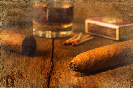 Cigar on old wooden table with the best whisky overlap with old wall textured background. retro filter.の写真素材