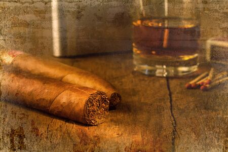 Cigar on old wooden table with the best whisky overlap with old wall textured background. retro filter.の写真素材