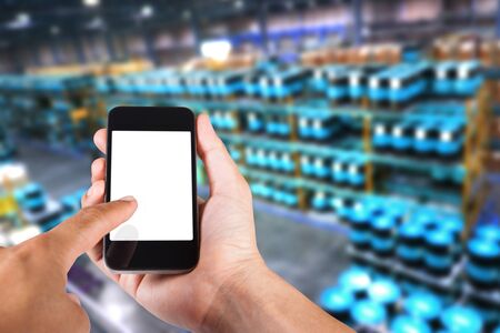 Person using smartphone white screen holder on hand with blurry background of industrial factory.の写真素材