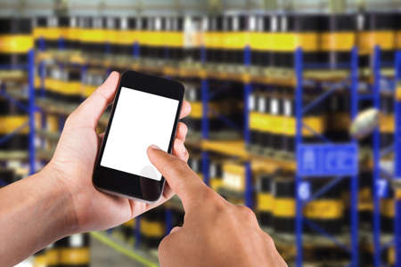 Person using smartphone white screen holder on hand with blurry background of industrial factory.の写真素材