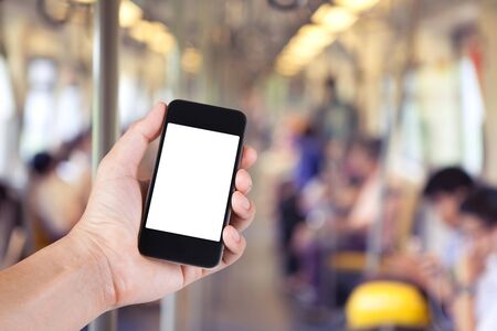 Person using smartphone white screen holder on hand with blurry background of passenger in skytrain in the big city.の写真素材