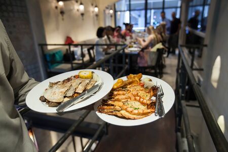 Waiter serving grill shrimp with india food in luxury party in  restaurant, Blurry background.の写真素材