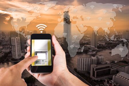 Man hand using smartphone mobile banking on top view cityscape in Bangkok, Thailand.