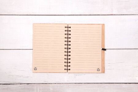 Notebook recycled paper blank on wood table.