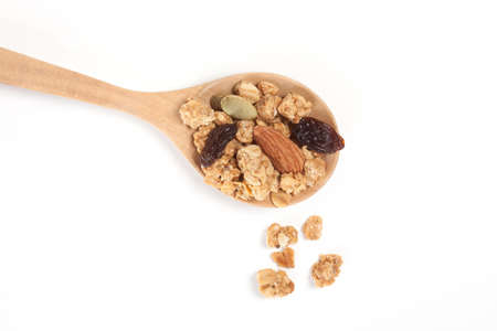 Close up Granola, Currant, Almond and Sunflower Seed on the wooden spoon isolated on white background.の写真素材