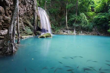 Flowing Water Into Blue Lake at Erawan Waterfall in Thailandの写真素材