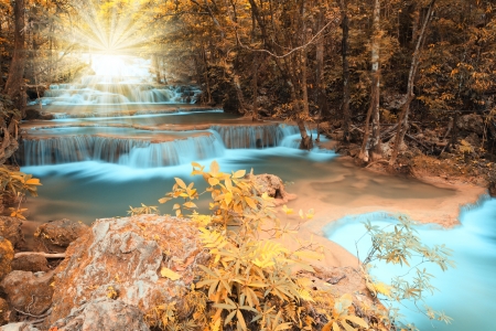 Autumn deep forest waterfall with light beam in Kanchanaburi, Thailandの写真素材