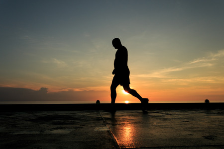 Silhouette Image of man walking on the helideck in the evening for excercisingの写真素材