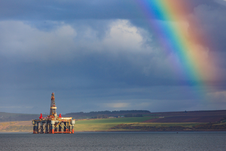 Semi Submersible Oil Rigs and Rainbow at Cromarty Firth in Invergordon, Scotlandの写真素材