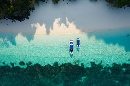 Aerial view from a drone of beautiful Nyaung Oo Phee island and boats on sunny day in Myanmar