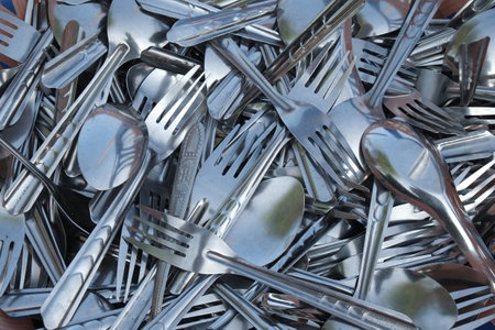 A random group of spoons and forks on a tray 