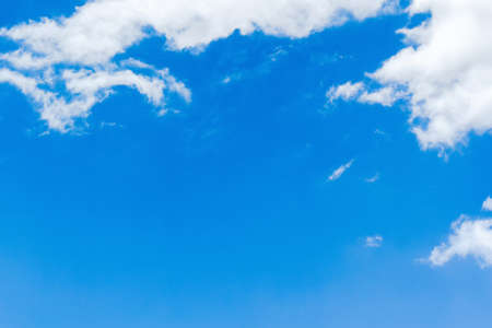 Blue sky background with tiny clouds. White fluffy clouds in the blue skyの写真素材