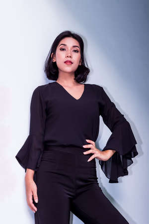 Young beautiful woman portrait in the blue wallの写真素材