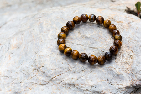 Tiger Eyes Stone Bracelet on the rockの写真素材