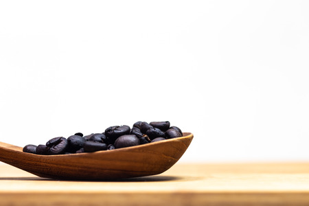 The roasted coffee beans on the wooden spoonの写真素材
