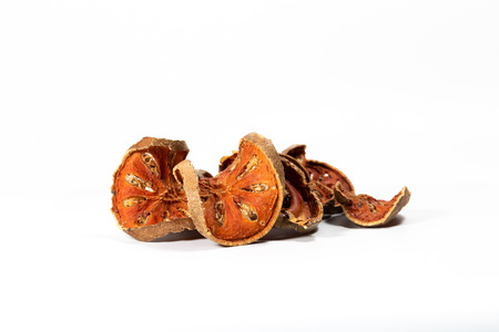 Slices of dried bael fruit on white background