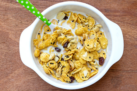 cereal made from cornflakes and caramel topped milk on wooden background
