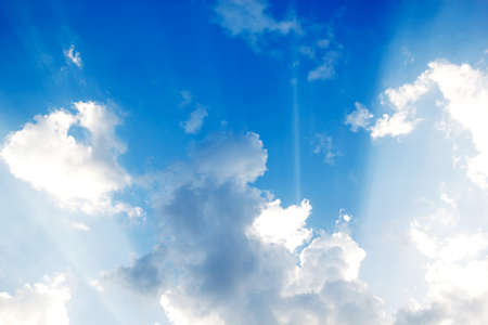 Blue sky with clouds and sun reflection