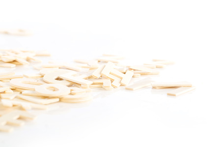 Pile of wooden block letters isolated over the white background as a typography background compositionの写真素材