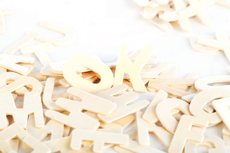 Pile of wooden block letters isolated over the white background as a typography background compositionの写真素材