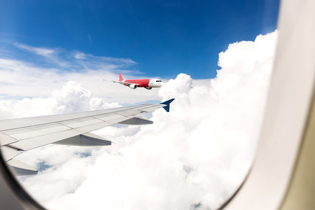 Looking through window aircraft during flight in wing with a blue skyの写真素材