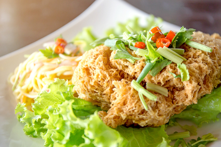 Crispy Catfish Salad Served white plate, Shredded Green Mango, Red Onion, Cabbage, Chili, Peanutの写真素材