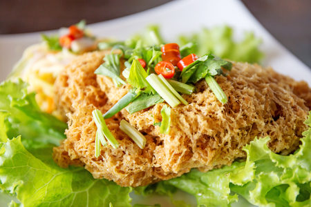 Crispy Catfish Salad Served white plate, Shredded Green Mango, Red Onion, Cabbage, Chili, Peanutの写真素材