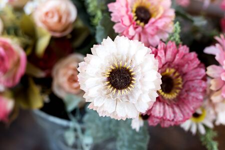 Artificial flower in the pot over wood tableの写真素材