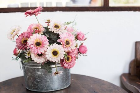 Artificial flower in the pot over wood tableの写真素材