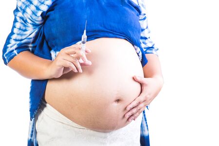 Pregnant woman and injection needle isolated on white backgroundの写真素材
