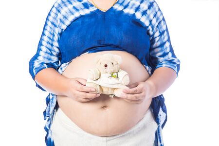 Pregnant woman with teddy bear isolated on whiteの写真素材