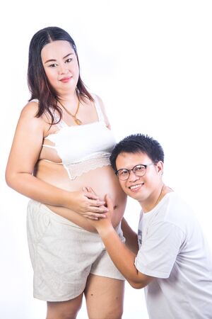 Asian young pregnant Couple Expecting Pregnancy Studio Portrait Isolated on White Backgroundの写真素材