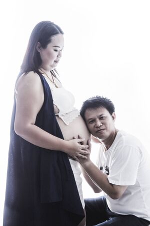 Asian young pregnant Couple Expecting Pregnancy Studio Portrait Isolated on White Backgroundの写真素材