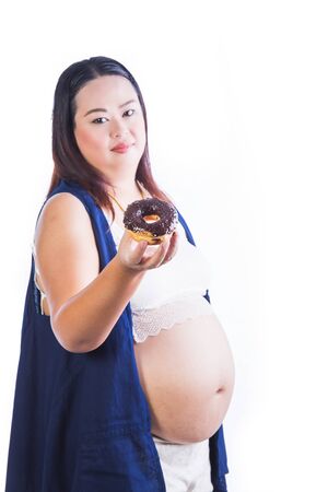 Pregnant woman with belly and sweet donut isolated on whiteの写真素材