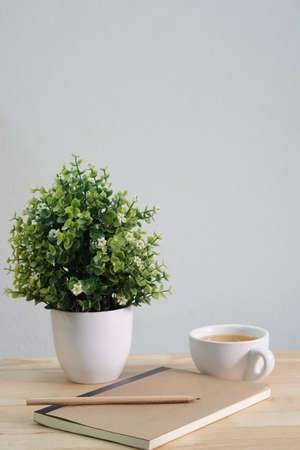 Artificial tree in a white ceramic pot on wooden table, copy space concept.の写真素材