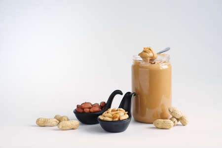 Peanuts and peanut butter placed on white wooden background.の写真素材