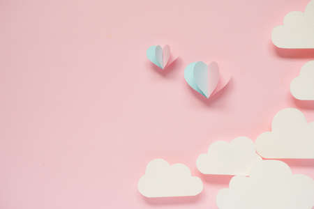 Paper cut in the shape of heart and folded like balloon floating in the air placed on pink background, valentine's day background concept.の写真素材