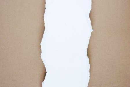 Ripped white paper placed on brown paperの写真素材