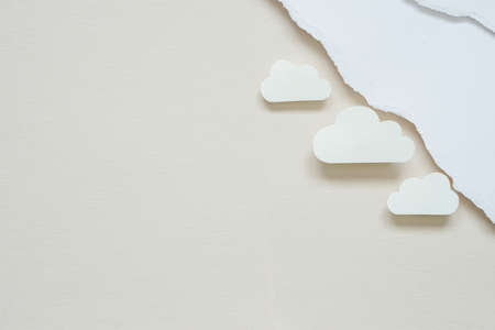 valentine's background ideas with white paper cut in the shape of clouds beside blank ripped white paper placed on cream colour paper for background.の写真素材