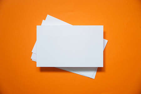 mock up of horizontal business card on orange background, top view.