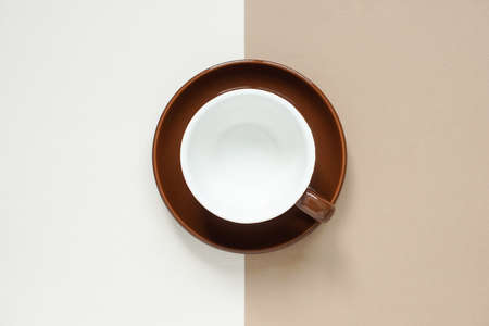 top view of empty circle brown ceramic mug on brown  ceramic coaster placed on the middle of brown background and cream colour background.の写真素材