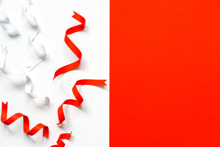 red and white ribbons paper on  white paper and blank red paper background, copy space on red background.の写真素材
